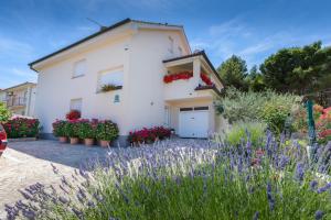 a white house with flowers in front of it at Apartments Hortensia in Pula