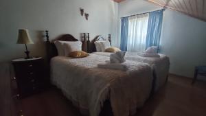 a bedroom with two beds with towels on them at Casa do Artesanato in Vila Nova de Cerveira