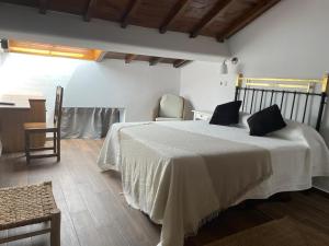 a hotel room with a bed, chair, and table at Hotel Casa Beletri in Béjar