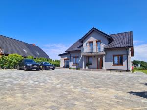 a house with two cars parked in a driveway at Morze u Sary - Wrzosowo 361, Dziwnówek in Dziwnówek