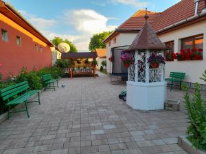 a patio with a gazebo and benches in a yard at Casa Miki in Haţeg
