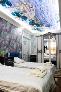 um quarto com 2 camas e um tecto azul e branco em Bonuluxhome em Samarkand