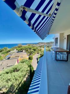 einen Blick vom Balkon eines Hauses mit Sonnenschirm in der Unterkunft Mimosas - Bel appartement avec une vue imprenable sur la baie in Cavalaire-sur-Mer