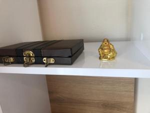Un estante con un maletín y una estatua de oro. en Hakuna Matata Guest House en Plovdiv