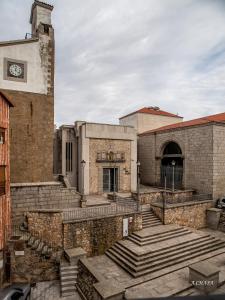 an old brick building with stairs and a clock tower at Auténtica buhardilla en el centro de Béjar in Béjar
