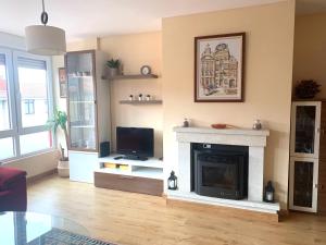 a living room with a fireplace and a tv at El trocito de mar in Luanco