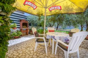 a table and chairs under an umbrella on a patio at Apartments Hortensia in Pula