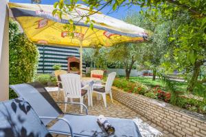 a patio with a table and chairs and an umbrella at Apartments Hortensia in Pula