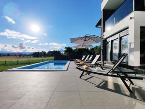 une terrasse avec des chaises longues et une piscine dans l'établissement Villa Biser Gacke, à Sinac