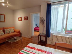 a living room with a couch and a fan at bayonne centre in Bayonne