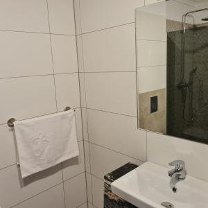 baño con lavabo, espejo y toalla en Pokój Zelwągi 15 en Mikołajki