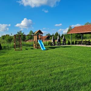un parque infantil con un tobogán en un campo de césped en Pokój Zelwągi 15 en Mikołajki