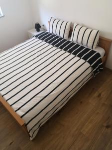 a bed with black and white striped sheets and pillows at Apartment Adi in Travnik