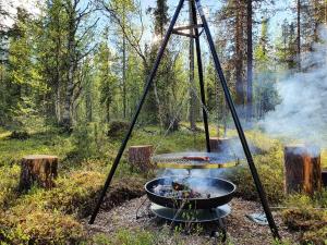 a bbq grill in the middle of a forest at Ylläs Terhakka - Uusi huvila kuudelle in Äkäslompolo