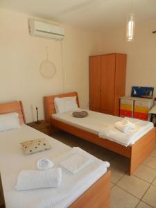 a bedroom with two beds and a dresser in it at Orizzonte Apartments Lefkada in Lefkada
