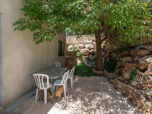 una mesa y sillas en un patio bajo un árbol en Panorama Golan נוף הגולן Дом в Галилее, en Safed