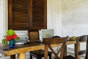 a wooden table with a laptop computer on it at OYO 90893 Mimpi Bungalows in Kuta