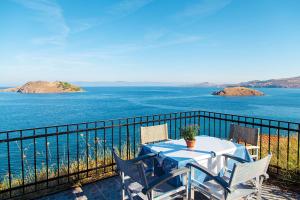 una mesa y sillas en un balcón con vistas al agua en Anaxos Hill, en Anaxos