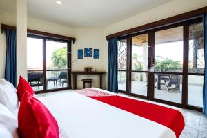 a bedroom with a large bed with red pillows at OYO 90893 Mimpi Bungalows in Kuta