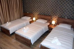 two beds in a hotel room with two lamps at Tulpan Hotel in Sheki
