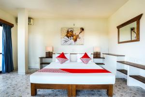 a bedroom with a large white bed with aviolinet at OYO 90893 Mimpi Bungalows in Kuta