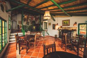 a dining room with tables and chairs and a fireplace at Estancia San Antonio in Guasca