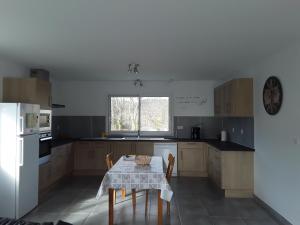 uma cozinha com uma mesa e um frigorífico branco em Maison individuelle neuve avec piscine em Limoux