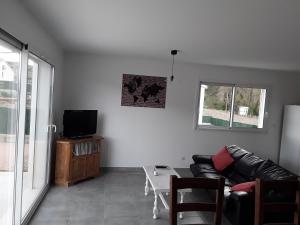 a living room with a couch and a tv at Maison individuelle neuve avec piscine in Limoux