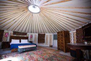 Gulmit的住宿－Roomy Yurts, Gulmit Hunza，蒙古包内一间卧室,配有一张床
