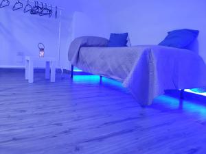 a bedroom with a bed and a table with blue lights at La Perla di Ele in Bari