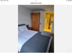 Dormitorio pequeño con cama y armario en Bosloe, en Helston
