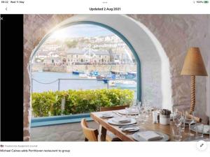 a table with a view of a harbor from a window at Bosloe in Helston