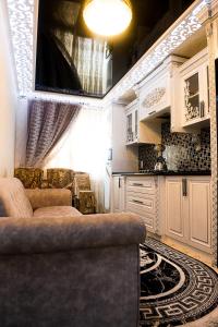 uma sala de estar com um sofá e uma cozinha em Bonuluxhome em Samarkand