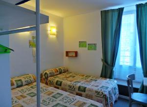 Habitación de hotel con 2 camas y ventana en Hôtel La Fontaine en Lourdes