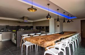 una gran mesa de madera en una cocina con sillas blancas en Hôtel Version Maquis Santa Manza en Bonifacio