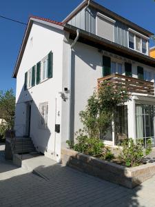 a white house with a door and some plants at Ferienwohnungen Bohner/Wohnung Elisabeth in Meersburg