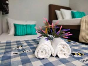 a hotel room with towels and flowers on a table at Homey 9pax 3BR MRT Cheras Tmn Suntex I HomeBrickz in Cheras
