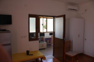 a room with a door and a table and a window at Guesthouse Benardo in Sarandë