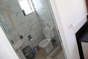 a bathroom with a toilet and a sink at Guesthouse Benardo in Sarandë +6 photos