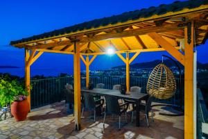 a wooden pergola with a table and chairs on a patio at Villa Valia Calda in Limenas