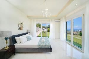 a bedroom with a bed and a large window at Villa Valia Calda in Limenas