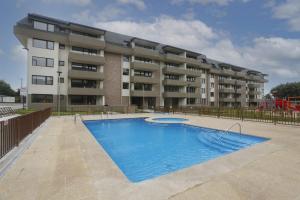 a swimming pool in front of a building at Departamento, Condominio Nueva Villarrica in Villarrica