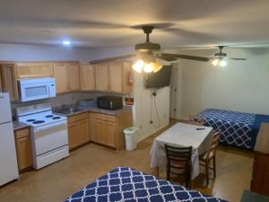 a kitchen with a table and a kitchen with a bed at Cotulla Executive Inn in Cotulla