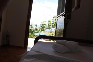 a bedroom with a bed with towels on it with a window at Guesthouse Benardo in Sarandë