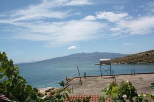 a chair sitting on the beach near the water at Guesthouse Benardo in Sarandë