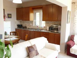 a living room with a couch and a kitchen at Kedrodasos House in Elafonisi