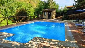 una piscina de agua azul en un patio en El Refugio de Los Molinos, en Cortegana