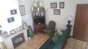 a living room with a green couch and a television at Casa do Artesanato in Vila Nova de Cerveira