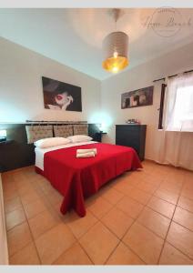 um quarto com uma cama com um cobertor vermelho em Residence House Beach - Apartment em Margherita di Savoia