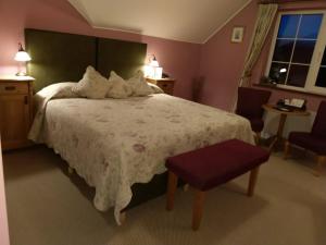 a bedroom with a large bed with a white comforter at Drumcreehy Country House B&B in Ballyvaughan